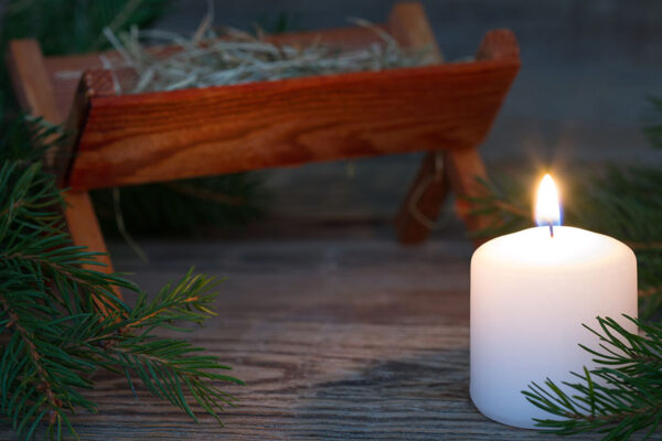 Fir tree branch with wooden note against blurred lights, space for text. Christmas music